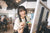 woman holding a paint palette and paintbrush painting on a canvas